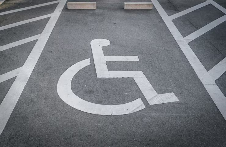 Parking lot with wheel stops and accessible signage to improve vehicle control and pedestrian safety