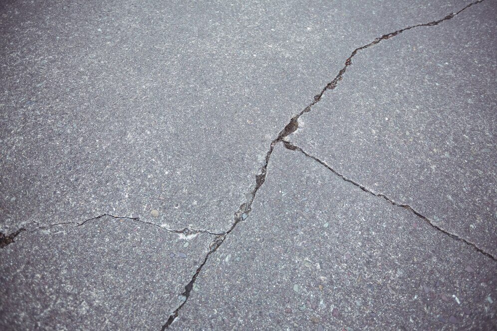 Cracked asphalt road surface indicating potential hazards and the need for asphalt crack repair
