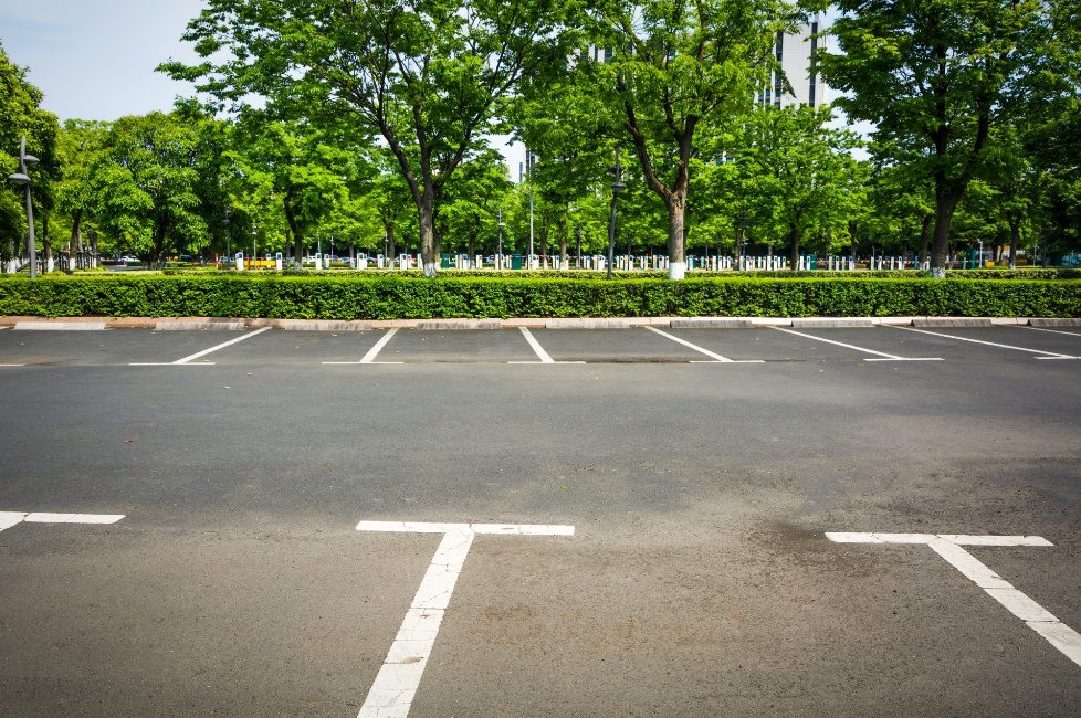Asphalt parking lot sealcoated to protect against UV rays and surface cracks
