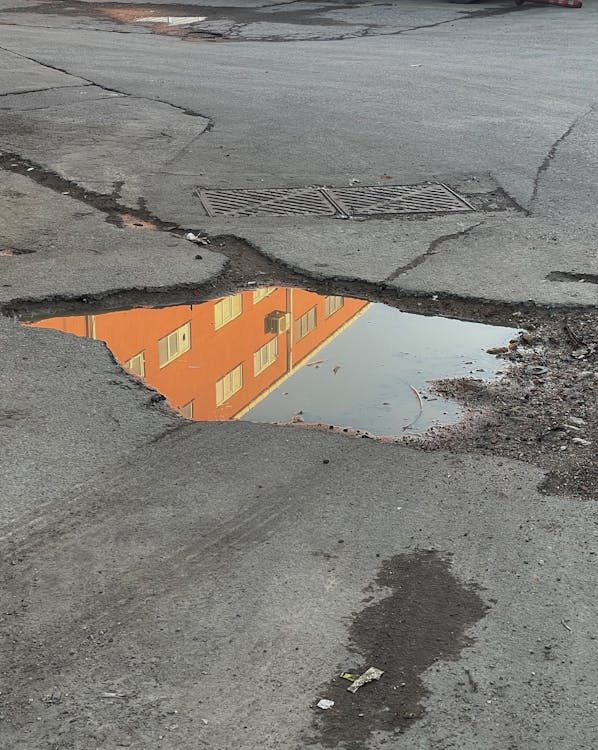 A large pothole in the middle of a parking lot is creating inconvenience for drivers and customers