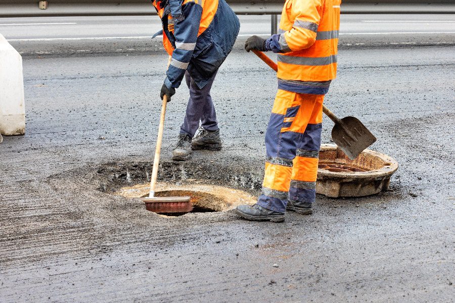 Professional asphalt contractors fixing a pothole to restore safety and protect a business’s reputation