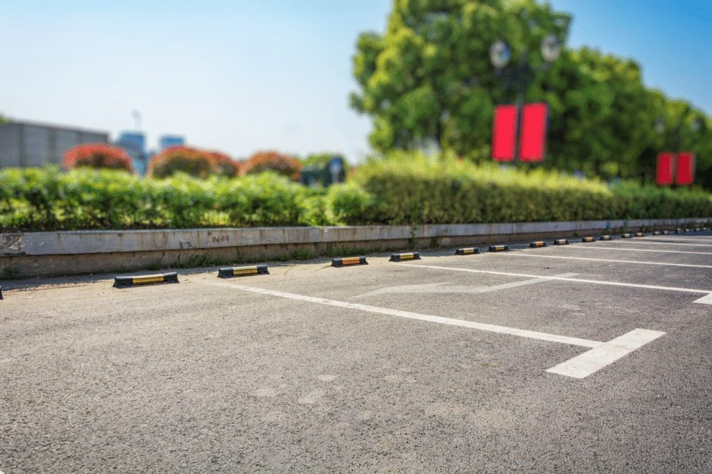 Organized parking lot with correctly installed wheel stops and clear line striping