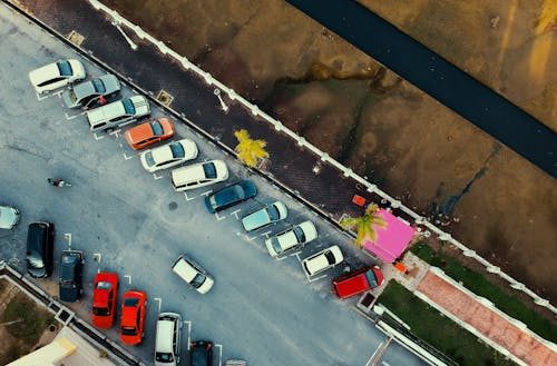 Parking lot with faded striping and missing wheel stops, creating safety risks for drivers and pedestrians