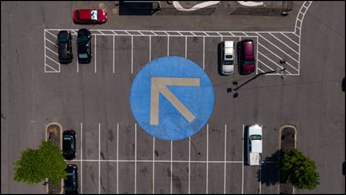 Parking lot with lines, signage, and parked cars