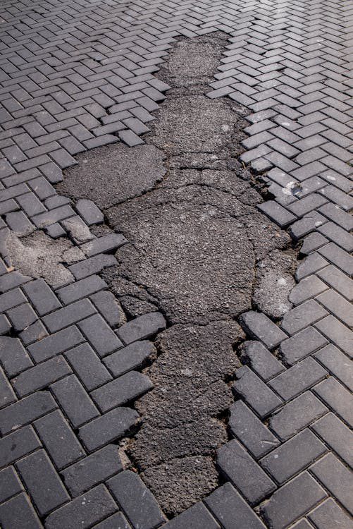 damaged cobble stone road with asphalt erosion