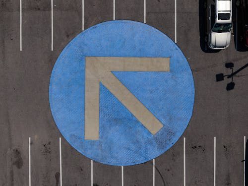 Freshly painted parking lot line striping showing clear parking spaces and directional markings.