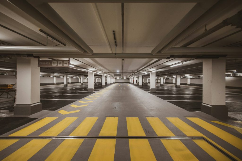 Diagonal yellow and black safety stripes painted on a concrete floor to warn of a hazard.