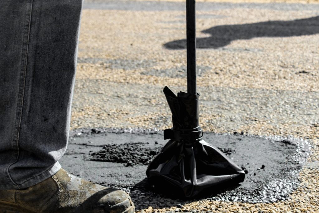 A person patching and repairing asphalt road