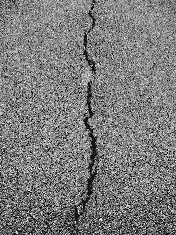 A driveway with cracked asphalt.