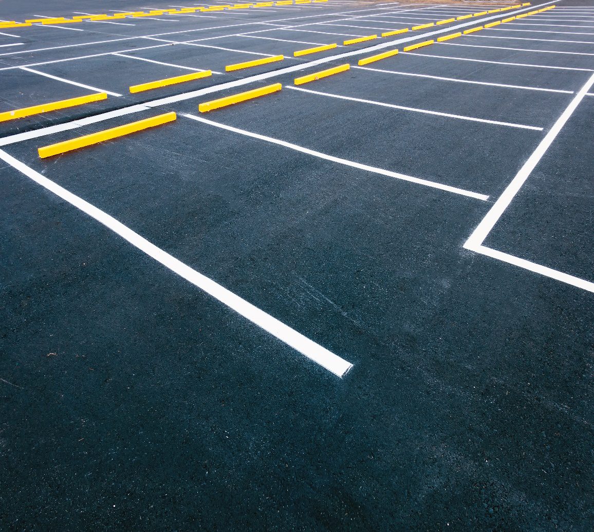 Parking lot symbol painted on asphalt surface for vehicle guidance.