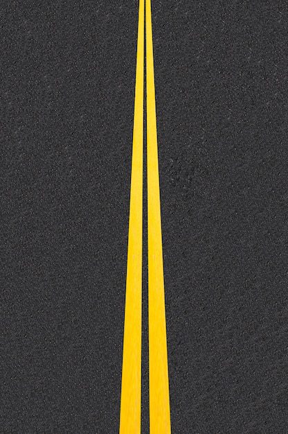 A smooth, freshly sealcoated asphalt road with crisp traffic lines, enhancing durability and appearance.
