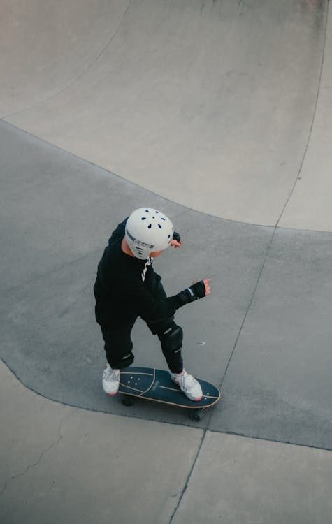 a boy skating on a concrete floor.