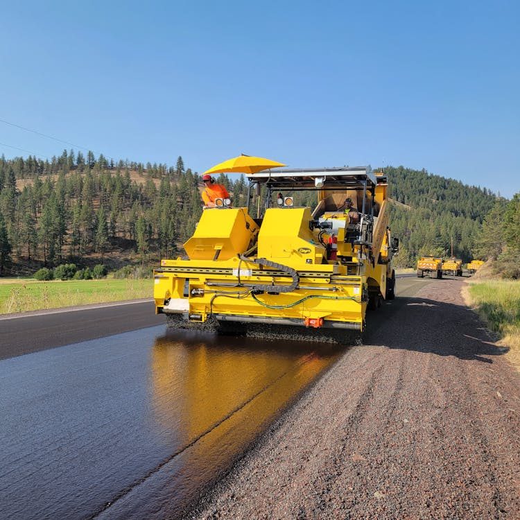 A worker operating asphalt sealcoating machinery