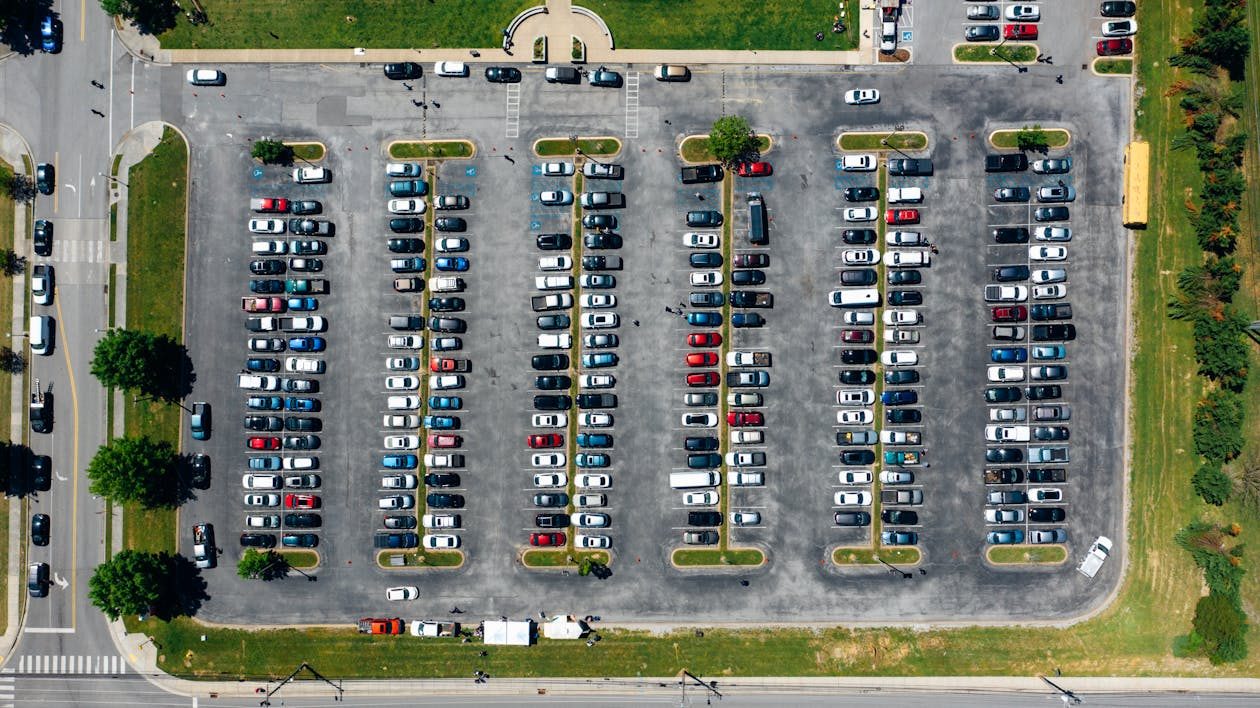 Aerial view of a crowded parking lot with cars parked very close due to limited space