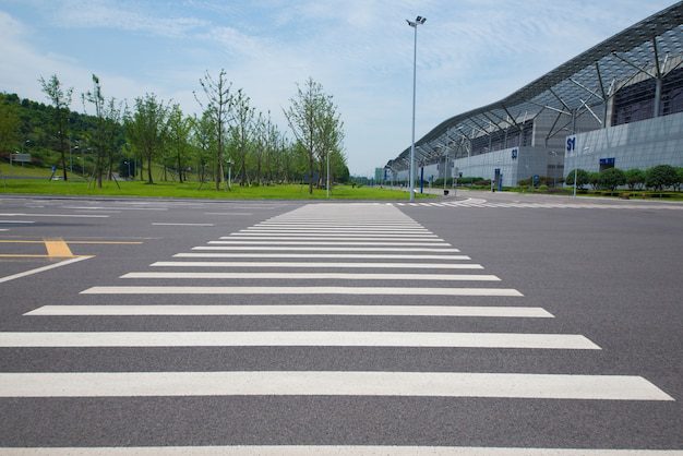 A well-marked zebra crossing on an asphalt road outside a facility ensuring pedestrian safety.
