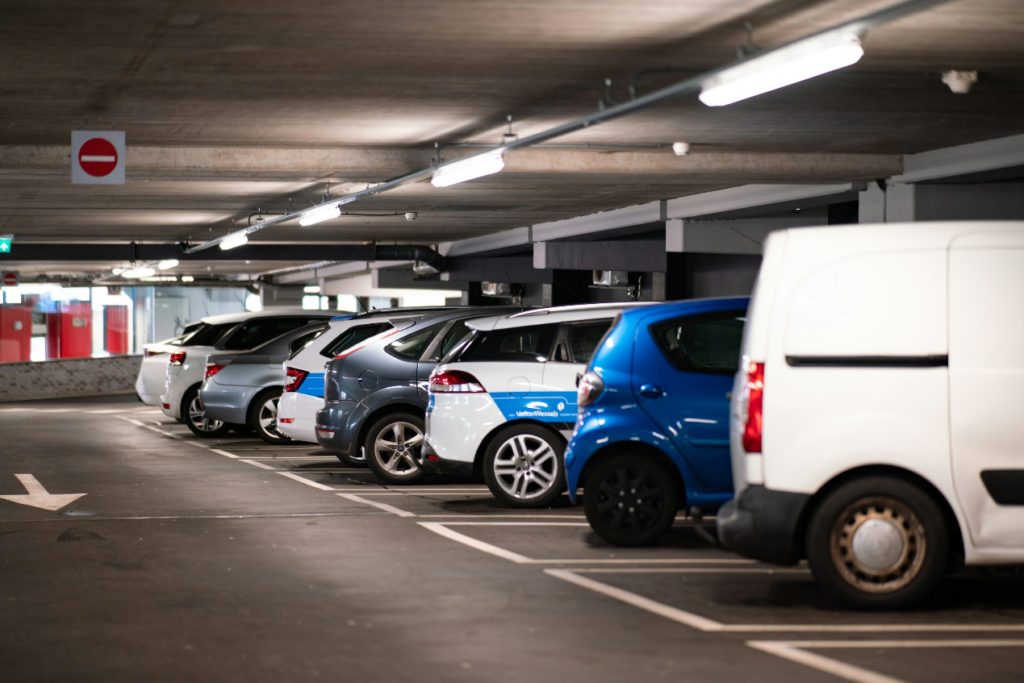 Cars neatly parked in an outdoor asphalt parking lot.